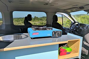 the interior of a van with a stove and sink.