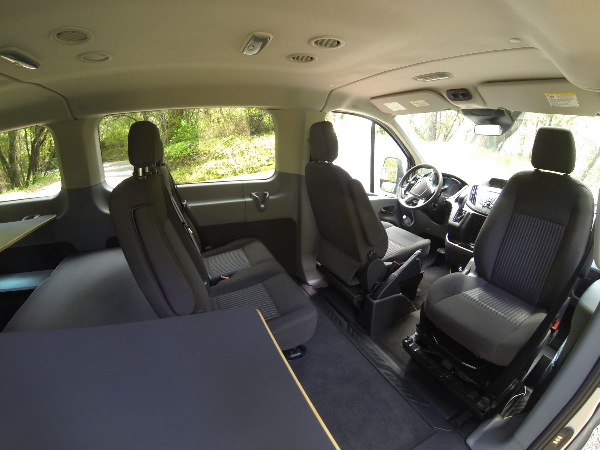 the interior of a van with two seats and a steering wheel.