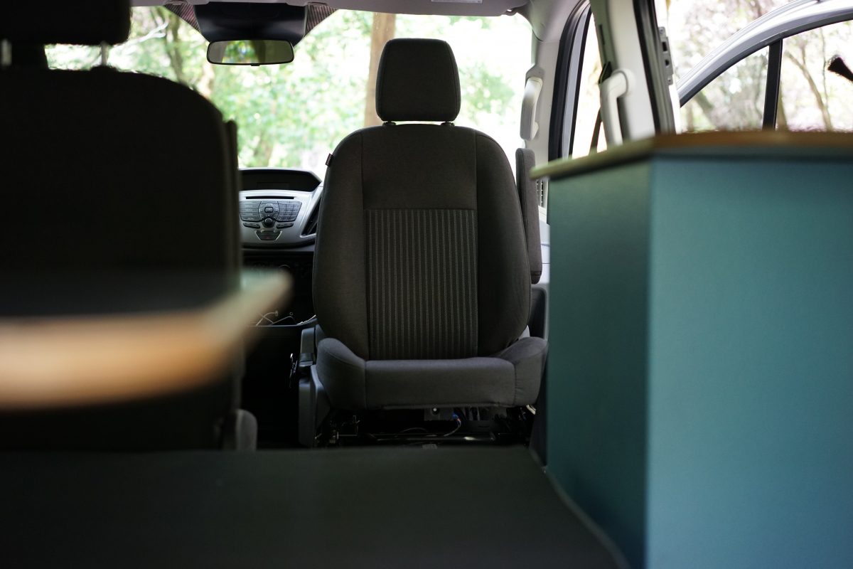 the interior of a van with seats and a table.