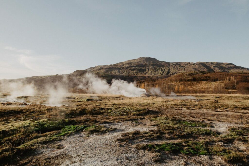 A landscape with a field of steam and mountains.