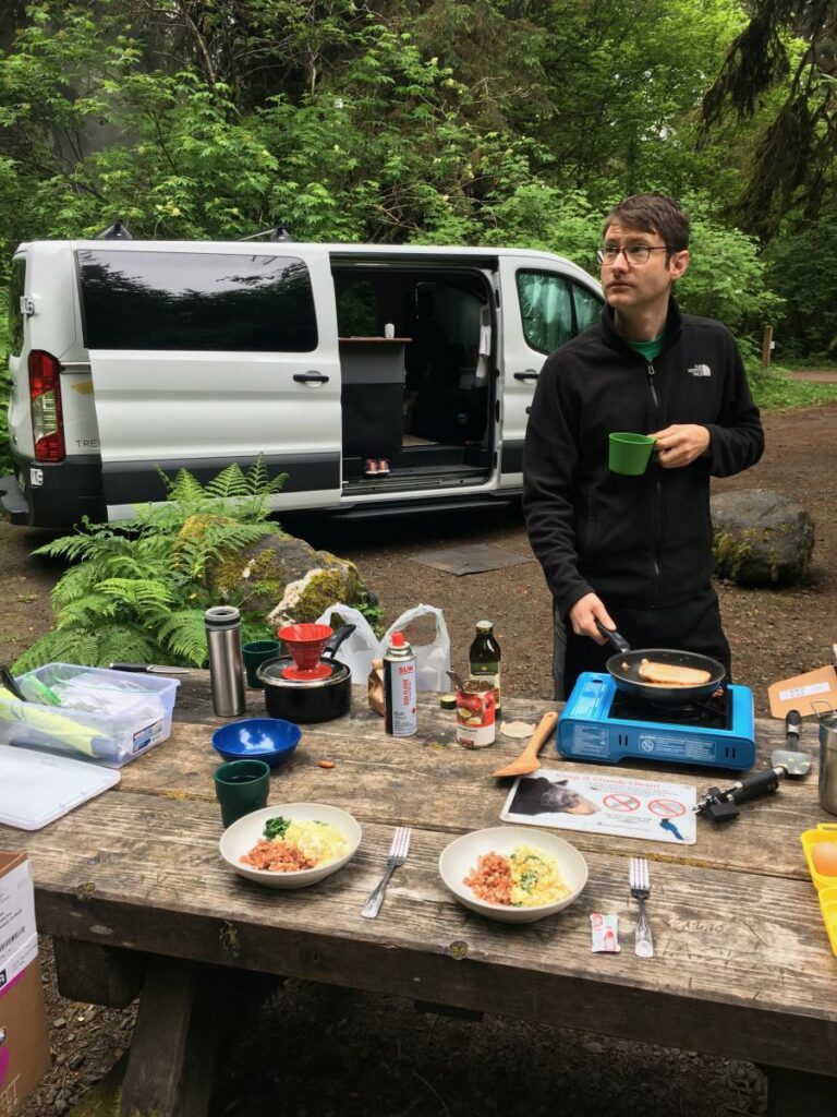 A man standing at a picnic table.